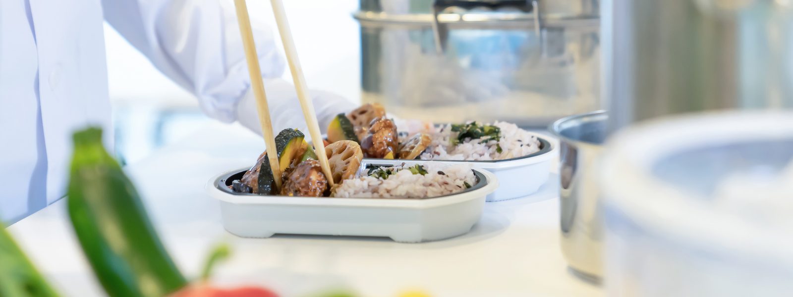 昼食をお弁当に盛り付けている手元